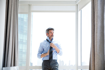 Business man adjusting necktie 