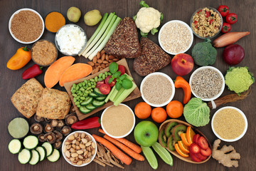 Health food for vegans with grains, seeds, nuts, peanut butter, almond yoghurt, herbs, spice, vegetables, fruit, cereals, wholegrain bread rolls. High in antioxidants, protein, dietary fibre & omega 3