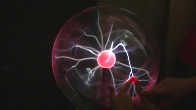 fingers touch the ball with plasma