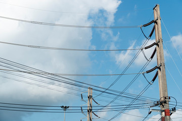 Electrical pole with many cable under blue sky. at Thailand.