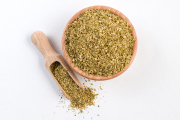 oregano herb in wooden bowl and scoop isolated on white background.top view