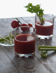 fresh tomato juice with celery. various options on a wooden table