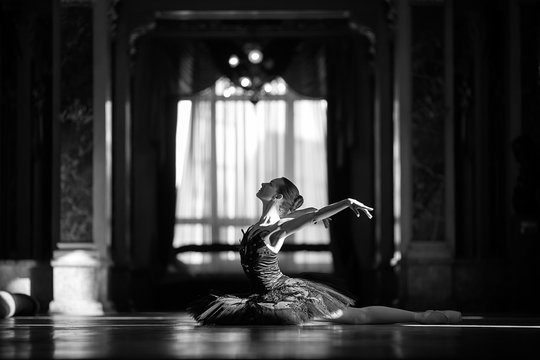 Beautiful ballerina dancing in a hall against the window.