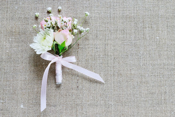Wedding boutonniere with pink rose, ranunculus and white chrysanthemum.