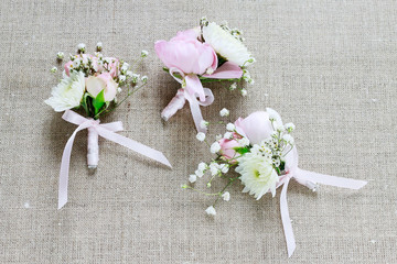 Wedding boutonniere with pink rose, ranunculus and white chrysanthemum.