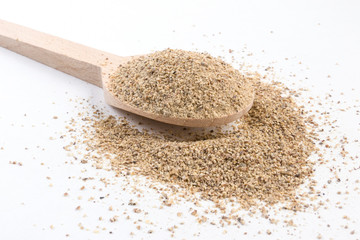 ground white pepper in wooden spoon isolated on white background