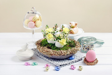 Easter table centerpiece with carnations, wax flowers, moss and eggs