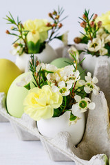 Easter table centerpiece with carnations, wax flowers, moss and eggs