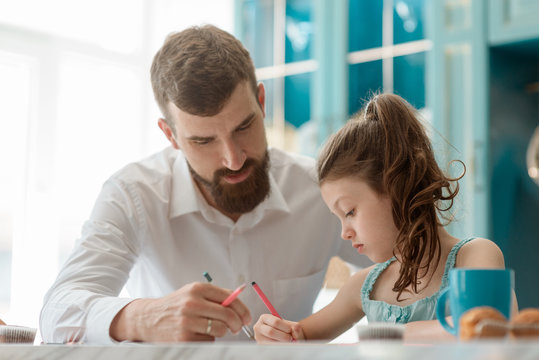 Dad helps daughter to draw