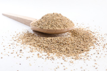 ground white pepper in wooden spoon isolated on white background