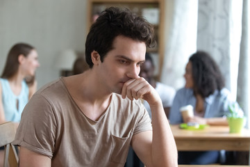 Upset thoughtful man sitting alone, low self-esteem, have no friends
