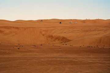 Fototapeta na wymiar Off-road vehicle over desert dunes wahiba sands at sunset (Oman)
