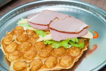 Bubble waffle, cooking Thai, Gongkog waffles with tomatoes, lettuce, cheese, red sweet peppers, smoked meat. Fast food concept, fast food, restaurant