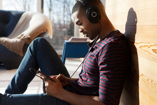 Young man listening to music on headphones - Powered by Adobe
