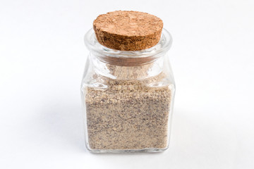 ground white pepper in a glass jar isolated on white background