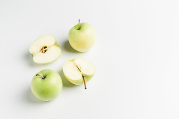 green apples on wooden stand on white background