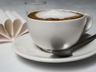 cup of coffee with cream on white background