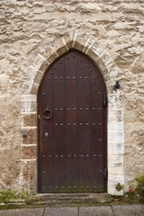 Fototapeta na wymiar Old wooden door on stone wall