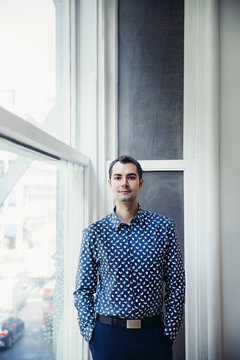 Young man standing by window 