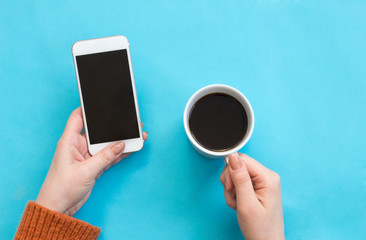 Using mobile phone holding coffee cup