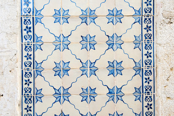 Old wall with traditional Portuguese decor tiles azulezhu in blue tones.