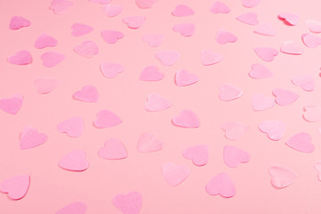 Pink background with heart-shaped confetti.