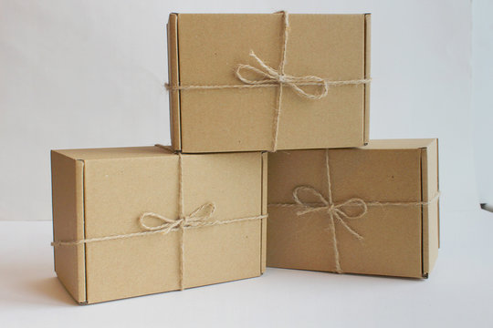 three cardboard gift boxes on a white background with twine