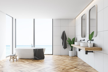 White tile bathroom interior, tub and sinks