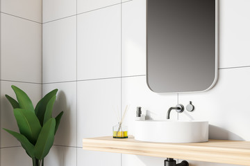 Side view of white tile bathroom with sink