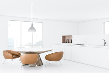 White kitchen with round table and armchairs