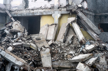A huge pile of gray concrete debris from piles and stones of the destroyed building. The impact of...