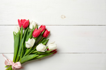 Fototapeta premium Bouquet of tulips on white wooden table, copy space for text. Invitation or congratulation banner mockup for spring holidays, International Womans Day, 8 march, Wedding, Mothers Day