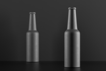 Two matt black bottles over black background