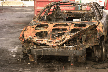Burned car, burned-out car body. Road wreck accident or arson fire burnt wheel car vehicle junk....