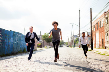 Four friends running in street 
