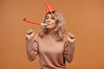 Isolated image of attractive cheerful happy young woman wearing stylish top and red cone cap...