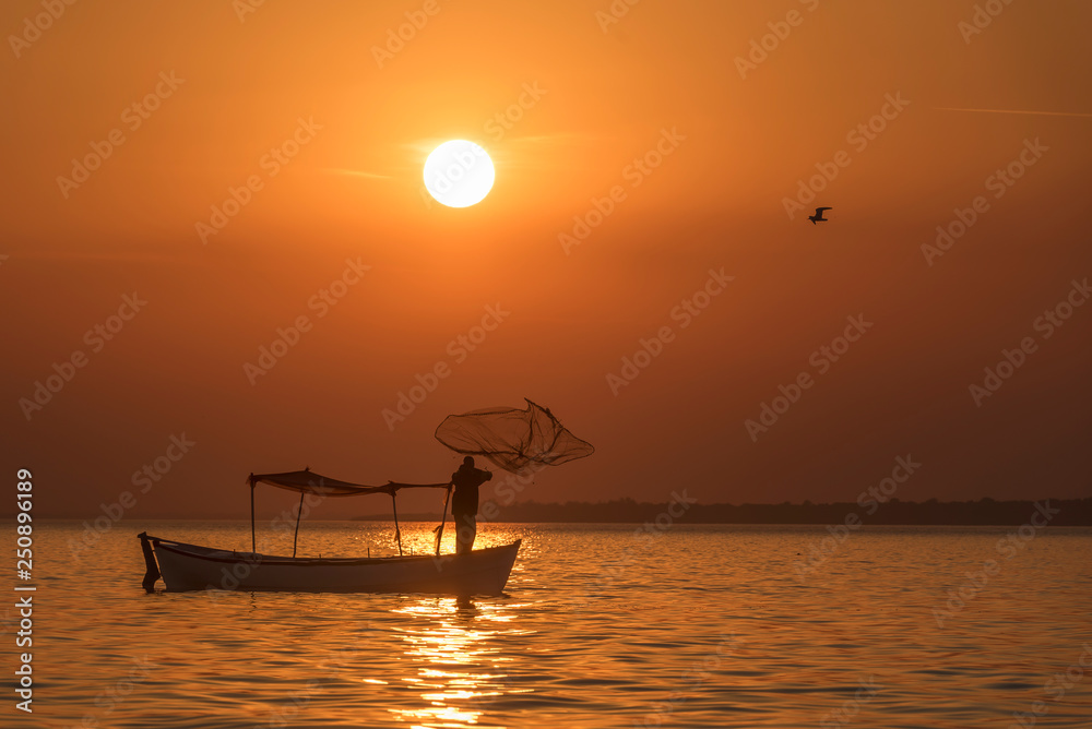 Wall mural sunset at the sea, fisherman