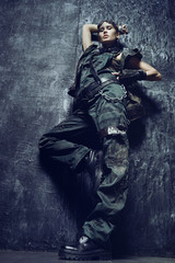 Young woman in brutal futuristic clothes on background 