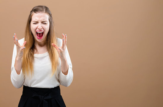Young woman feeling stressed on a brown background
