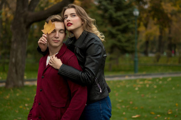 Fototapeta premium the couple hugs and sadly, the girl hugs the guy from behind and leans a yellow sheet to his face