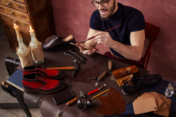 happy positive man applying the dye in the insoles, close up cropped photo