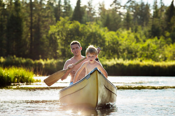 Father with son (4-5) paddling in rowboat 