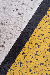 Asphalt highway texture with cracked white and yellow stripe