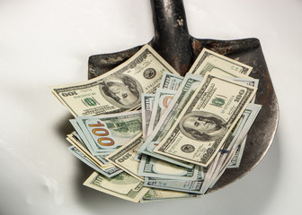 Money, one hundred dollars, banknotes on an old construction shovel, on a white background.