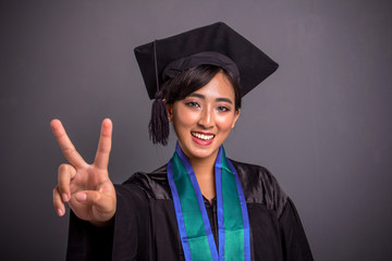 Pretty student peace sign graduation closeup portrait