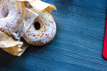 flat lay top view of the donuts bought in the bakery shop, packed in a paper-plastic bag wooden...