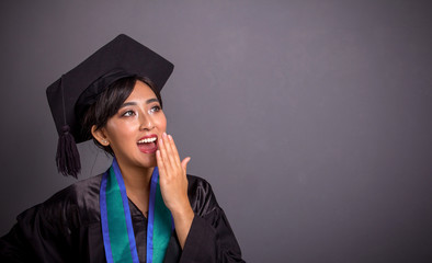 Girl in graduation outfits seeing a shocking amusing thing