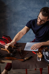 young busy employee spending time at workshop. close up photo, guy putting a brush on the desk