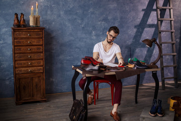 Leather craftsman writing a letter to a customer , full length photo
