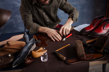 man cutting a pattern for goods, close up cropped photo